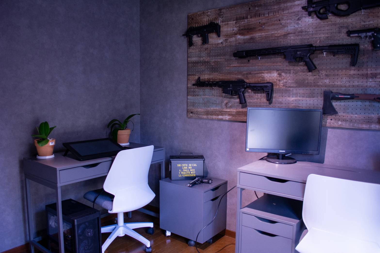 銃モックの壁とデスクが並ぶミリタリーエリア全景